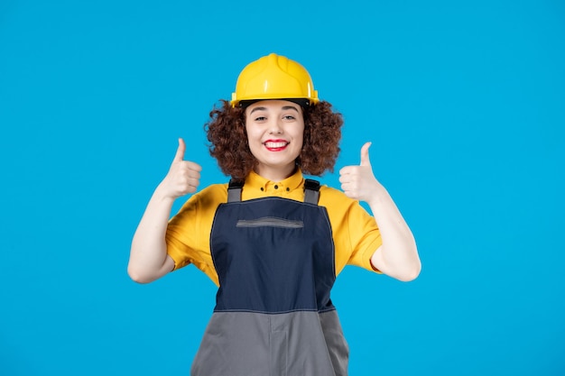 Female builder in uniform on blue