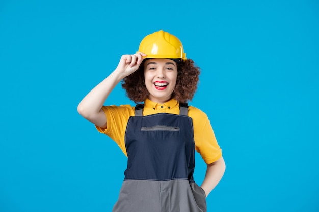 Female builder in uniform on blue