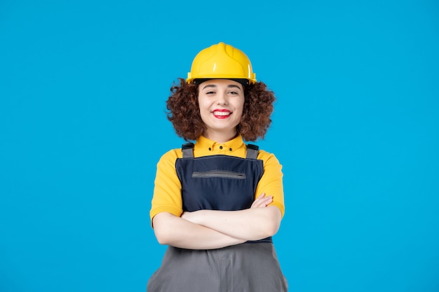 Female builder in uniform on the blue