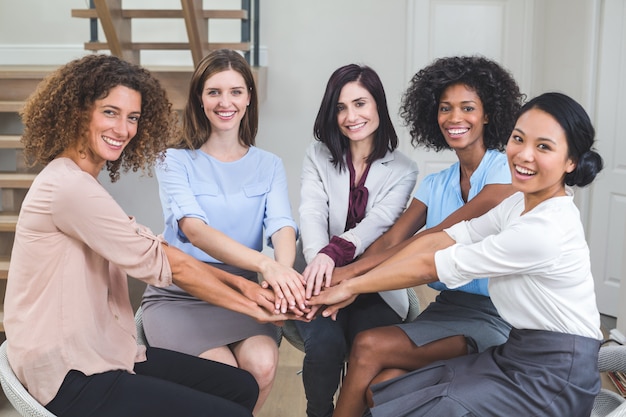 Female business colleagues putting their hands together