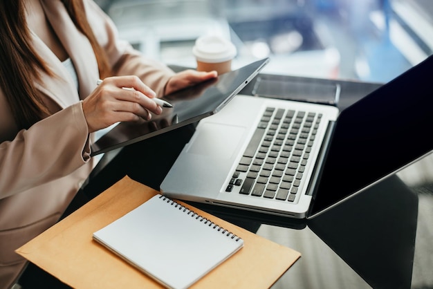 Female businessman and financial concepts about office work Analysts discuss business with tablet and laptop as a tool