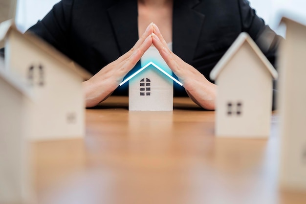 Female businesswoman hands protecting house Home protecting concept