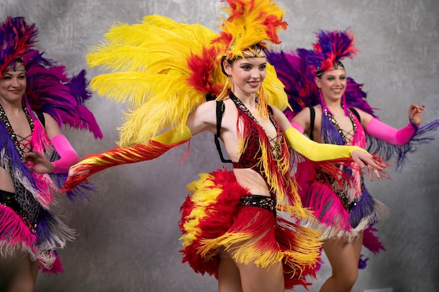 Female cabaret performers dancing backstage in feathers costumes