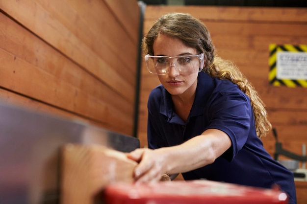 Photo female carpenter using plane in woodworking woodshop