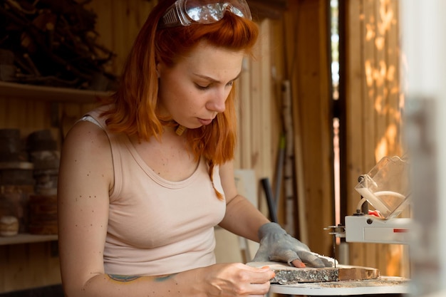 female carpenter working with wood in workshop