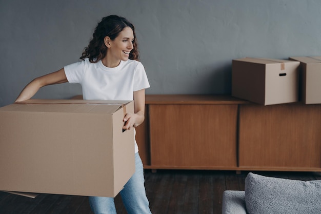 Photo female carrying cardboard box to room on moving day mortgage tenancy parcel delivery service ad