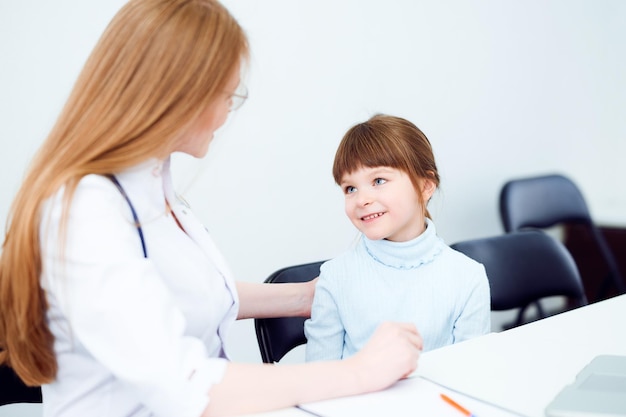 Female caucasian doctor examining little girl in hospital