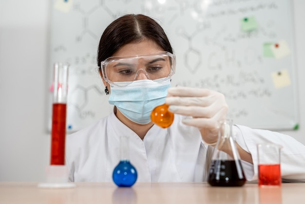 female caucasian laboratory assistant looking at scientific sample in test tube the laboratory