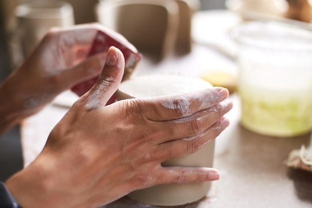 Female ceramist working in pottery studio Ceramist's Hands Dirty Of Clay Process of creating pottery Master ceramist works in her studio