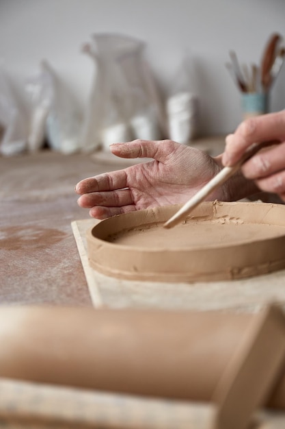 Female ceramist working in pottery studio Ceramists Hands Dirty Of Clay Process of creating pottery Master ceramist works in her studio