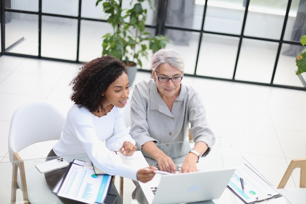 Female colleagues met in the office hall discussing work issues