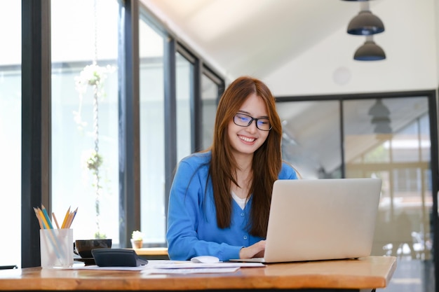 A female college student uses a computer to access the Internet for online learningxA