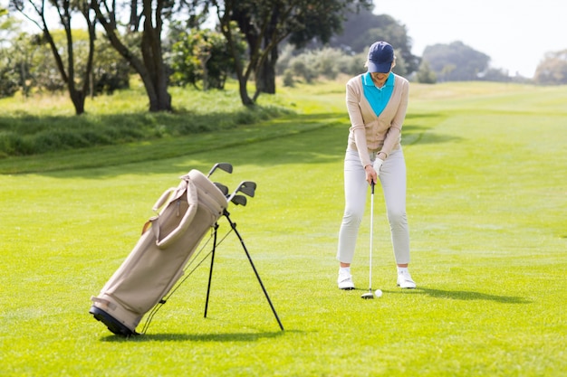  Female concentrating golfer teeing off 