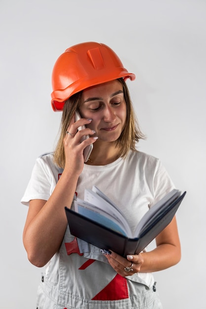 Female construction worker holding a folder with documents in her hands Isolated on a plain