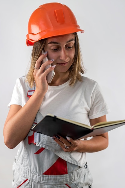 Female construction worker holding a folder with documents in her hands Isolated on a plain