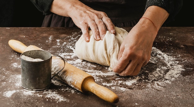 Female cook kneading pizza dough