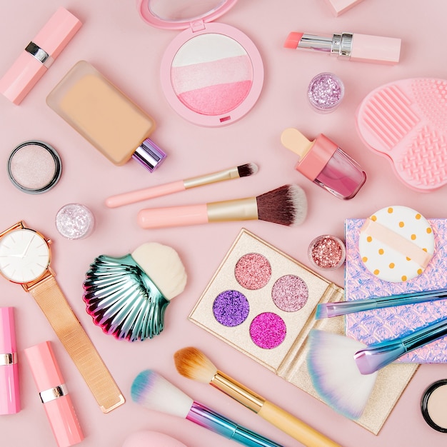 Female cosmetics collage with lipstick brush and other accessories on pink background