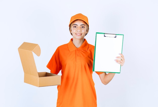 Female courier in orange uniform holding an open cardboard box and presenting the customer list