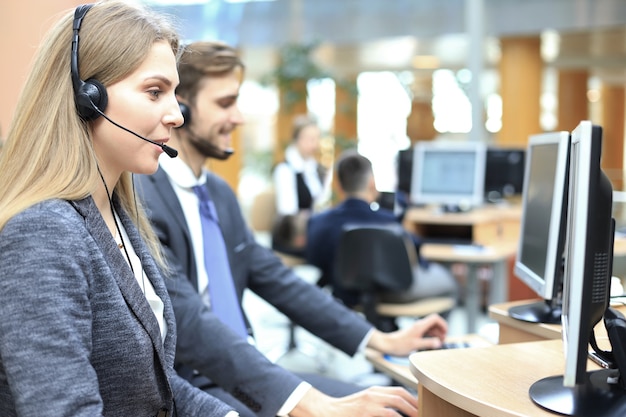 Female customer support operator with headset and smiling.