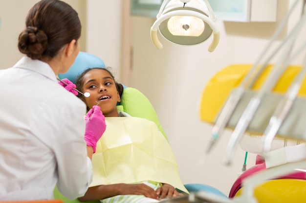 Female dentist in aseptic gloves holding dentist tools