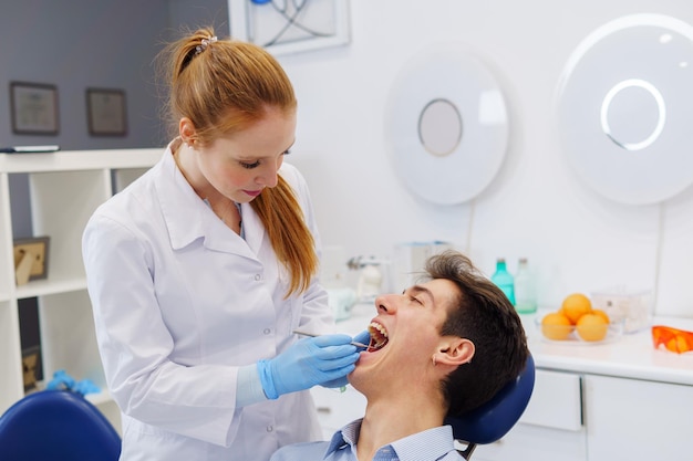 Female dentist doing teeth examination in modern office