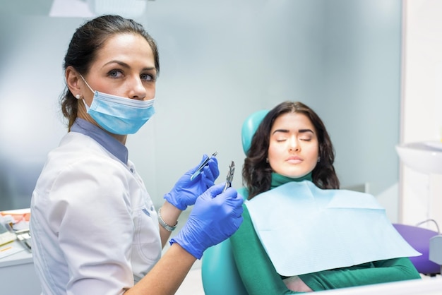 Female dentist holding pliers