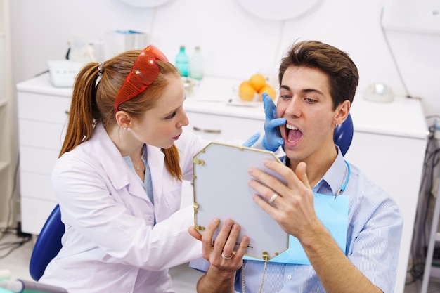 Female dentist showing teeth to patient