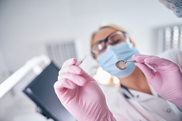 Female dentist using instruments during patient treatment