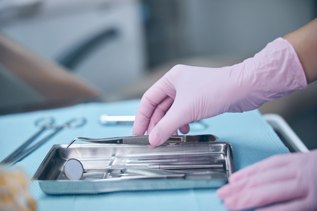 Female dentist using sterile instruments during treatment