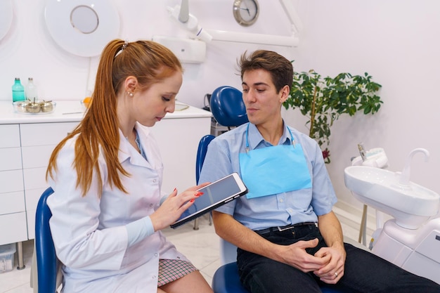 Female dentist using tablet near man