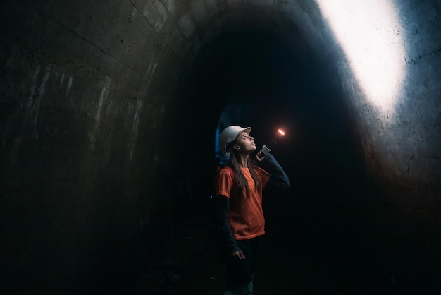 Photo female digger with flashlight explores the tunnel