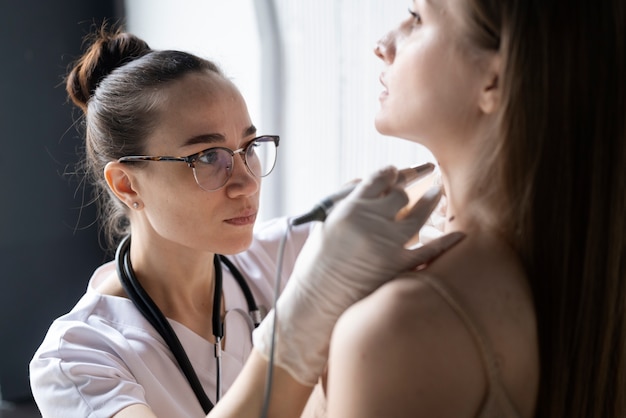 Female doctor diagnosing a melanoma on the body of a female patient