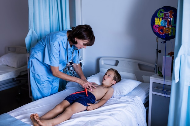 Female doctor examining abdomen of patient