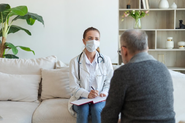 Female doctor examining older senior man in doctor office or at home old man patient and doctor have