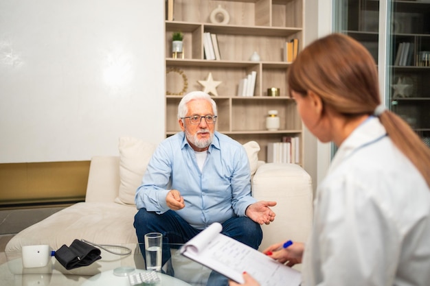 Female doctor examining older senior man in doctor office or at home old man patient and doctor have