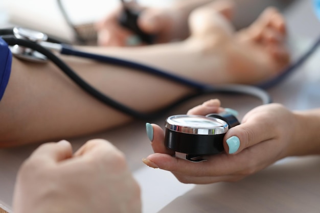 Female doctor hands male patient blood pressure measurement