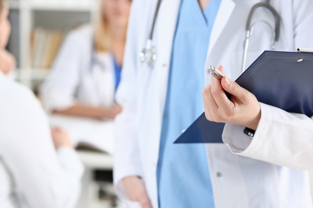 Female doctor hold clipboard pad and fill medical history list