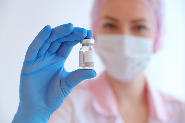 Female doctor holding syringe and COVID19 vaccine Healthcare And Medical concept