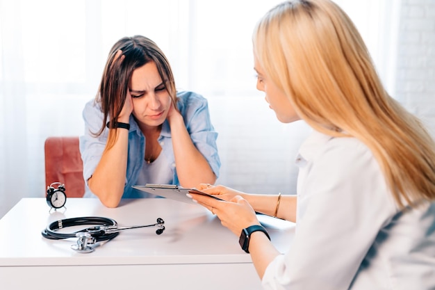 Female doctor at the hospital and a patient with head ache Migraine