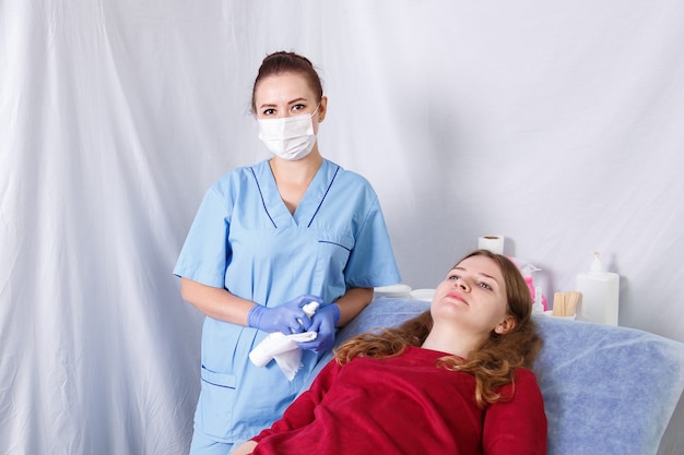 A female doctor is next to a patient lying on a couch