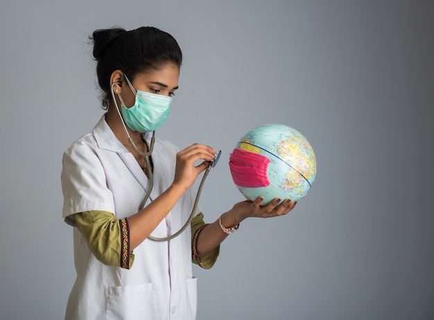 Female doctor listening to the Earth globe with stethoscope