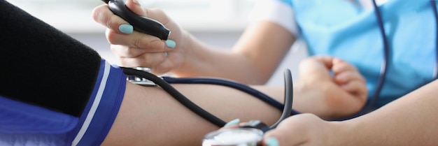 Female doctor measures the blood pressure of a man hands closeup