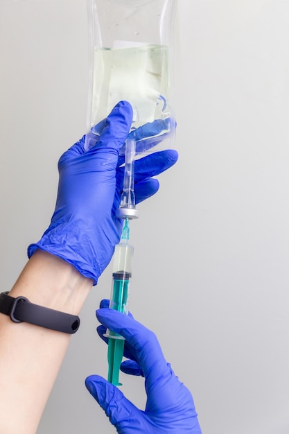 A female doctor or nurse in rubber gloves prepares the injection