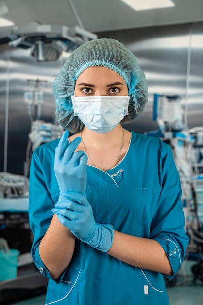 Photo female doctor in operating room in a special uniform injecting medicine through the patient