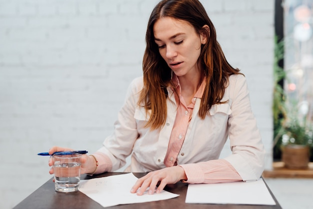 Female doctor sits at her desk and writes a prescription.