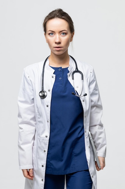 Photo a female doctor in a surgical suit with a stethoscope holds a laptop in her hands electronic doctors appointment