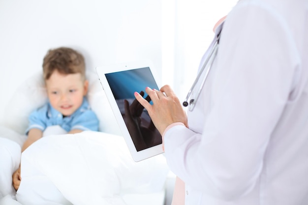 Female doctor using a digital tablet closeup of hands Health care concept or children's therapy