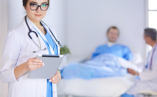 Female doctor using tablet computer in hospital lobby