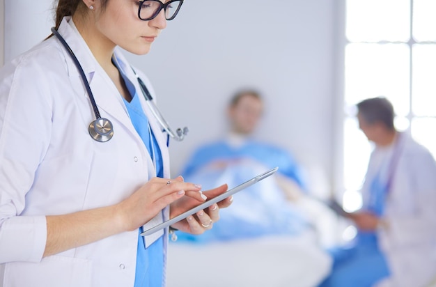 Female doctor using tablet computer in hospital lobby