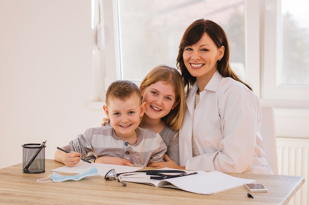 Female doctor with kids posing, looking at camera